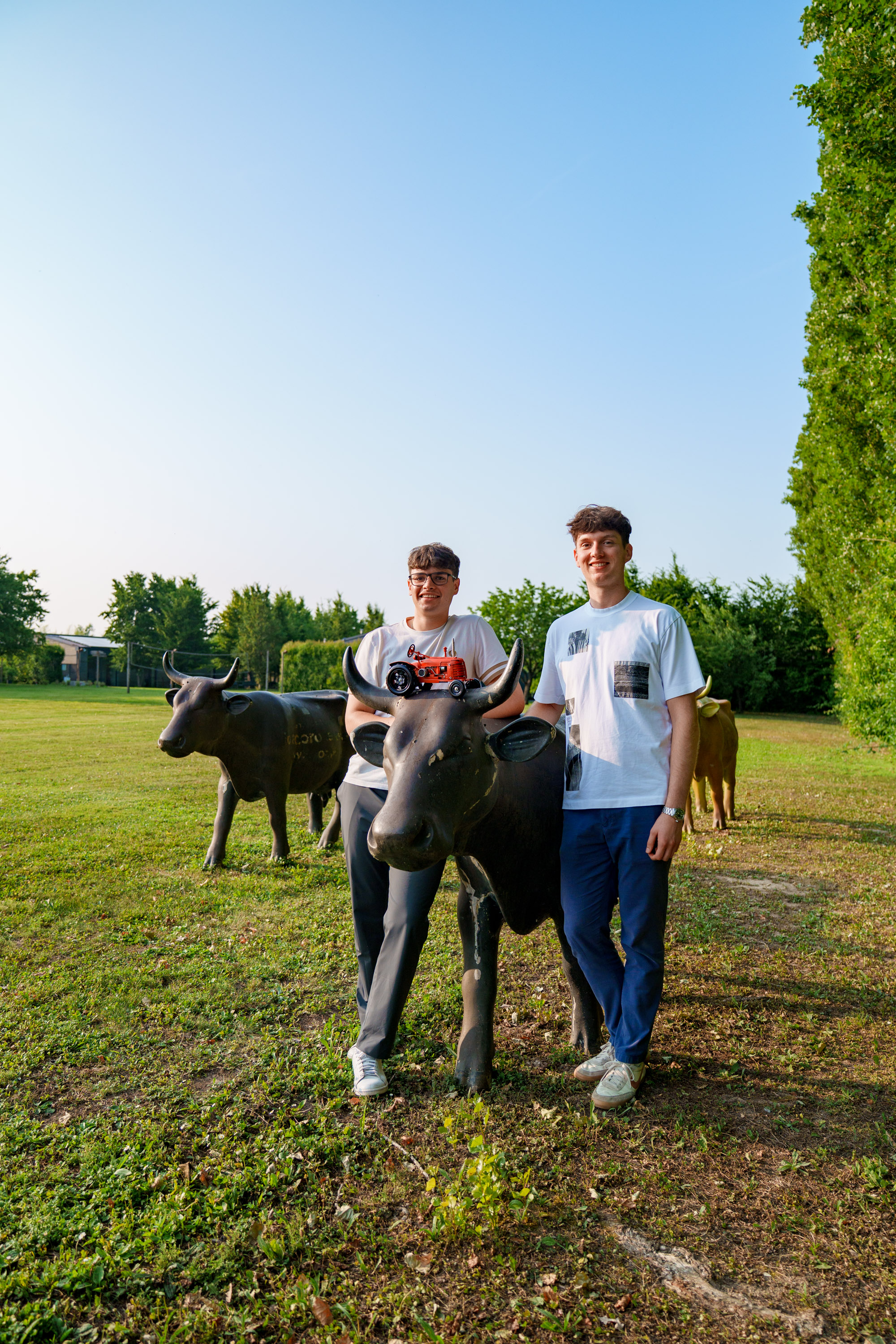 MooNitoring founders Sebastiano and Filiberto with dairy cows in pastoral farm setting